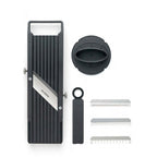 Set of grooming tools including a black and silver device, bowl, and combs on a white background